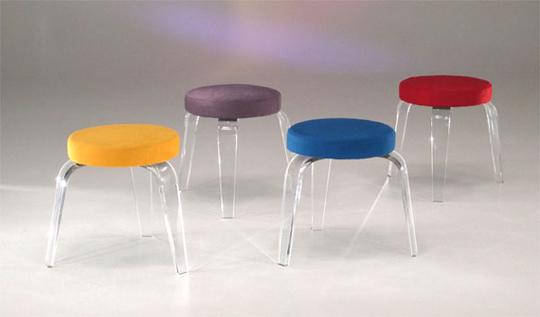 Taburetes acrílicos con asientos de diferentes colores.