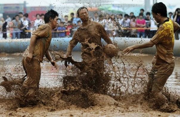 Players compete for the ball in the mud during a 2012 Swamp Soccer World Cup China match at Olympic Green area, next to the National Stadium in Beijing La pelota sí se mancha