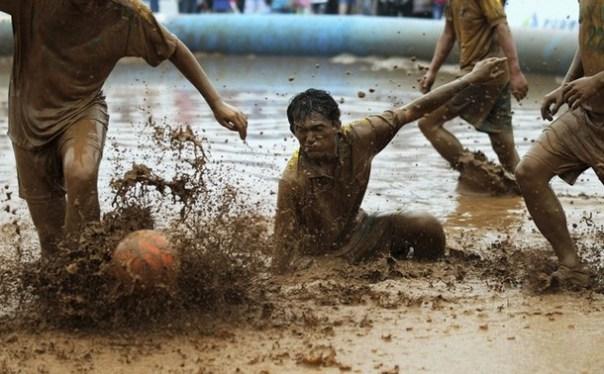 Players compete for the ball in the mud during a 2012 Swamp Soccer World Cup China match at Olympic Green area, next to the National Stadium in Beijing La pelota sí se mancha