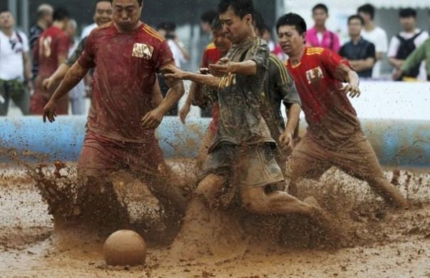 Players compete for the ball in the mud during a 2012 Swamp Soccer World Cup China match at Olympic Green area, next to the National Stadium in Beijing La pelota sí se mancha