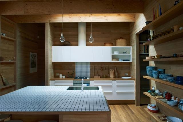 Una cocina con suelos, techos y paredes de madera Una cocina con suelos, techos y paredes de madera