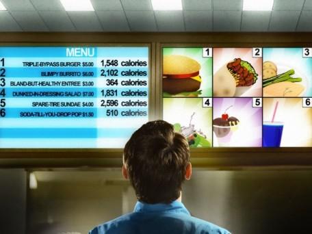 Man reading fast food menu with calorie chart