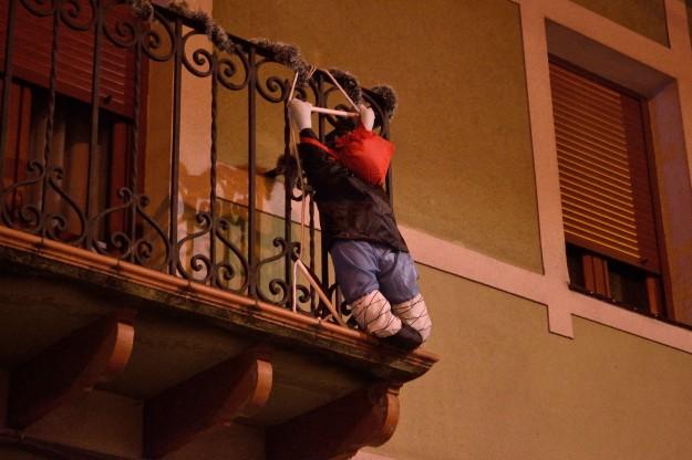 Un personaje de Olentzero colgando de un balcón