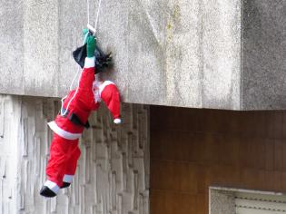 Lo han dejado colgando a la intemperie Papá Nöel el tenaz, bolsa en mano, persiste una y otra vez en seguir entregando regalos - para el, no hay riesgo suficiente que se lo impida.