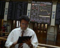 La Bolsa de Madrid gana un 1,88% y cierra en 8.658,3 puntos Un periodista trabaja en el parqué de la Bolsa de Madrid el 20 de julio de 2012