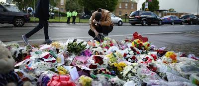 Crónicas desde la escena del crimen con montones de flores, fotos de la víctima y velitas junto a personas llorando desconsoladas