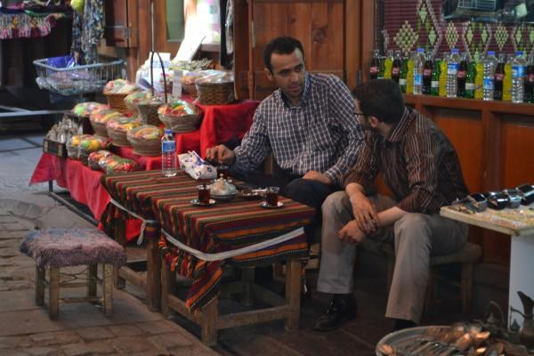 ¿”Ser” o “hacer”? La filosofía de vida del comerciante turco Dos comerciantes beben té en un bazaar turco