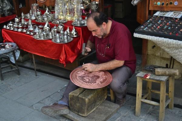 ¿”Ser” o “hacer”? La filosofía de vida del comerciante turco Algunos sí que trabajan duro, como este hombre grabando un plato de bronce
