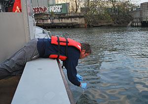 Persona tomando muestra de agua en el Rio Hudson