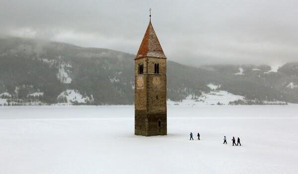 Haikyo, turismo en lugares abandonados Church steeple peeking out of a frozen lake in the village of Graun