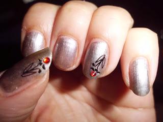 Manicura plateada con piedrecita roja. Manicura plateada con piedrecita roja.