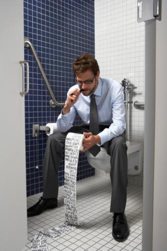 Lista por un día. Da un empujón extra a tu productividad. Businessman sitting on toilet writing list on paper