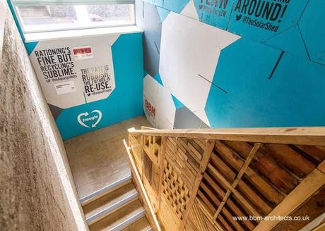 Cajas, persianas, maderas de obras de construcción y tierra cruda apisonada se ven en el interior Escalera interior y materiales diversos recuperados de desechos