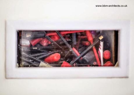 Hay materiales inusuales rellenando las paredes Ventana que muestra cepillos de dientes como relleno de pared