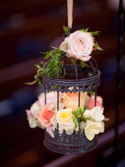 Unexpected flower ideas - Hanging lanterns or birdcages from the trees at your outdoor venue is a nice touch, but take it a step further by having them decked out in flowers for added color and texture.