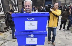Un hombre con las urnas donde se depositan los votos del referéndum.  (Andy Rain / EFE)