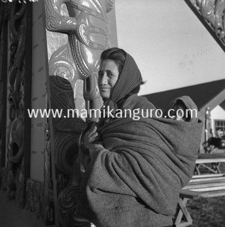 6_-1094957288_unidentified_maori_woman_holding_a_child_on_her_back_at_te_kaha_11_jul_1944