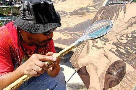 Artista Jordan Mang-osan haciendo un pirograbado solar