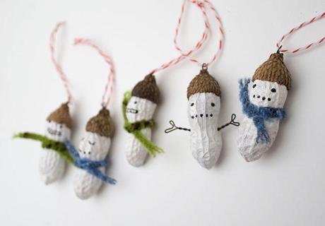 Adornos navideños hechos con cacahuetes con forma de muñecos de nieve