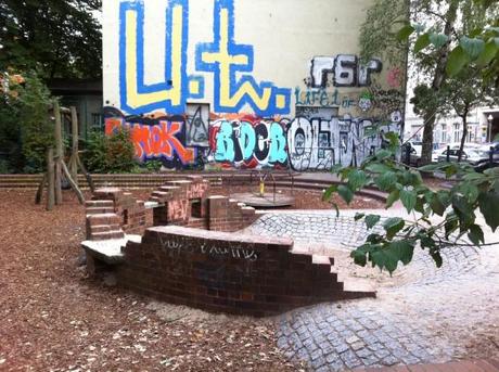 Espacios de juego en Berlín | eu:KIDS Pequeño espacio de juego en un solar en esquina en Wrangler Strasse y Curvy Strasse (Kreutzberg) con una pequeña fortaleza en ladrillo y adoquín. El suelo es de arena, adoquín y de corteza de arbol tratada. Foto: A.Walliser