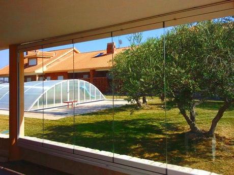 cerramientos-de-terraza-cortina-de-cristal-jardín-con-piscina