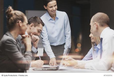 smiling female boss talking to business team