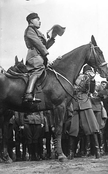 Personajes de la Segunda Guerra Mundial: Benito Mussolini Mussulini a caballo pasando revista. Fuente y autoría: Bundesarchiv, Bild 102-08300 / CC-BY-SA
