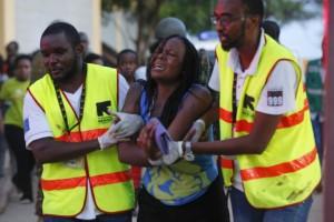 Dos sanitarios ayudan a una mujer que ha escapado de Garissa. (EFE)