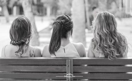 Tres chicas en banco parque con peinados y pelo suelto