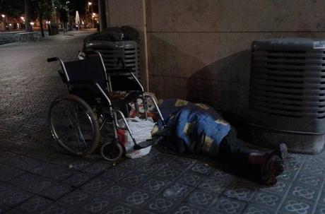 Una persona, junto a su silla de ruedas, durmiendo esta noche en la esquina de Consell de Cent con Urgell Una persona, junto a su silla de ruedas, durmiendo esta noche en la esquina de Consell de Cent con Urgell