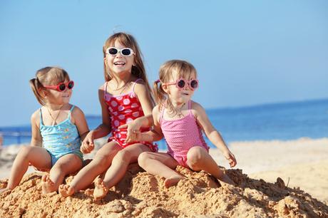 Happy kids playing at the beach in summer