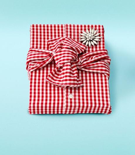 Libro de regalo envuelto con una camisa y un broche