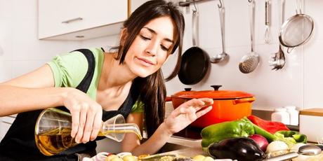 Los beneficios del aceite de oliva , una vida sin infartos Woman pouring olive oil over fish