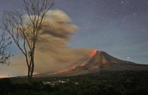 In this photo made with a slow shutter speed, Mount Sinabung spews hot lava and volcanic ash as seen from Jeraya, North Sumatra, Indonesia, early Tuesday, Oct. 14, 2014. Mount Sinabung, among about 130 active volcanoes in Indonesia, has sporadically erupted since 2010 after being dormant for 400 years. (AP Photo/Binsar Bakkara)