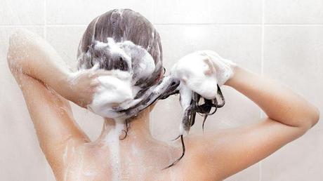 Por qué escoger champús sin sulfatos mujer lavándose cabello