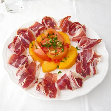 Ensalada de jamón, caqui y tomate con aliño de aceite, ajo y perejil