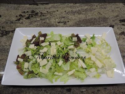 Ensalada con escarola, hoja de roble, lechuga, rabas de calamar, queso, pan tostado en cuadraditos y semillas de amapola.