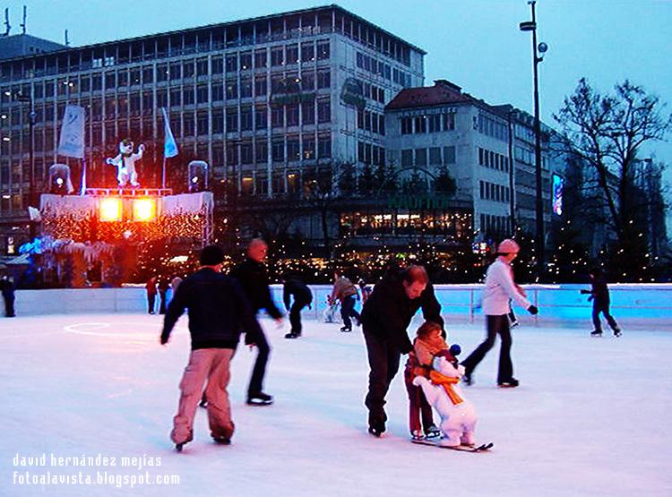 Gente patinando en Munich, Alemania, en una pista al aire libre en época navideña