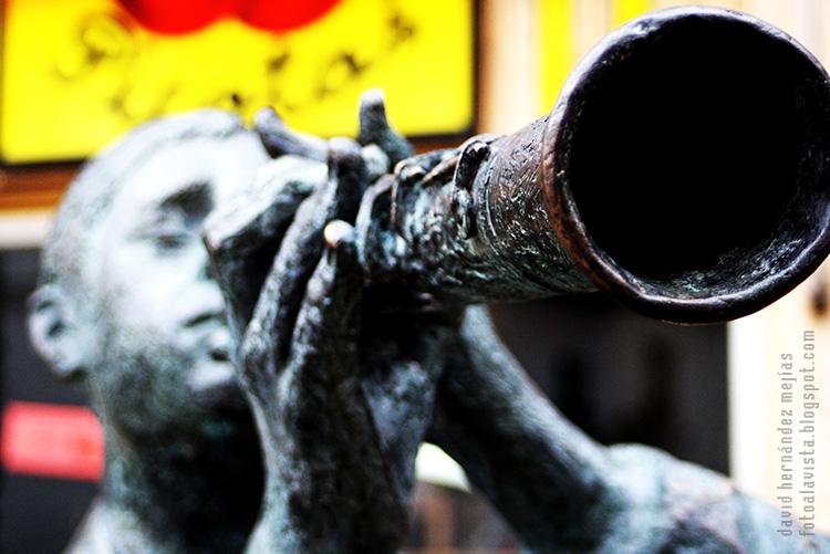 Escultura urbana en bronce de hombre tocando el clarinete perteneciente a un conjunto de piezas de temática musical, en Torrejón de Ardoz, Madrid