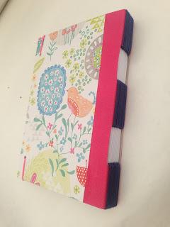 Cuaderno rosa con encuadernación de ojal.