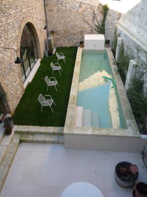 Piscina tipo alberca con un caño que vierte agua en todo momento