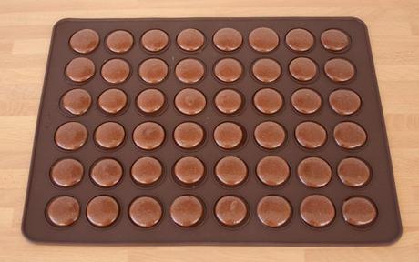 Macarons de chocolate rellenos de chocolate blanco Sobre un tapete de silicona realizar unos botones con la masa de los macarons
