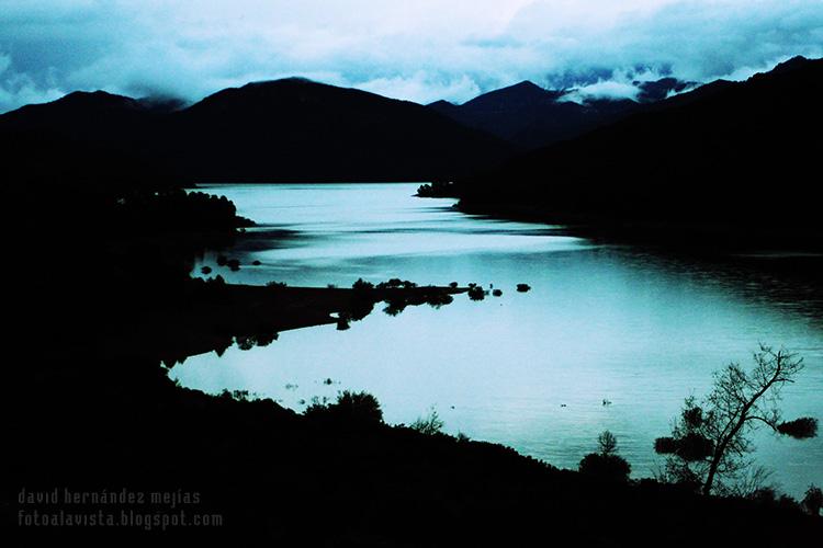 Vista de laguna de la sierra de Cazorla, Jaén, mientras cae una noche desapacible, oscura, en tinieblas y tenebrosa