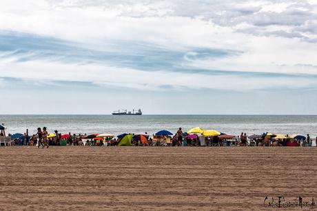 Paisaje  marino con arena,mar nubes y barco en el horizonte