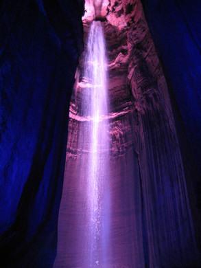 La misteriosa maravilla de una cascada subterránea iluminada por luces multicolores. La misteriosa maravilla de una cascada subterránea iluminada por luces multicolores.
