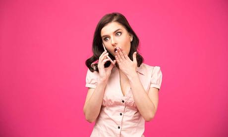 Surprised young woman talking on the phone