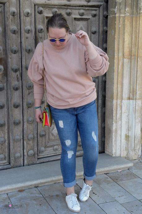 look con sudadera rosa y mangas abullonadas con lazo en la espalda de pull & bear jeans remangados de vioelta by mango y sneakers