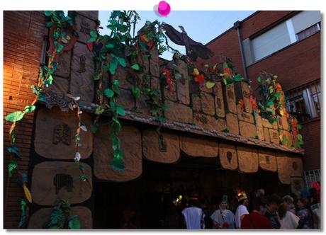 de noche, la fachada del colegio, decorada como unas ruinas de la selva maya