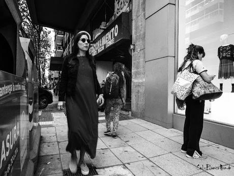 Foto callejera en Blanco y Negro.Mujer con gafas caminando.
