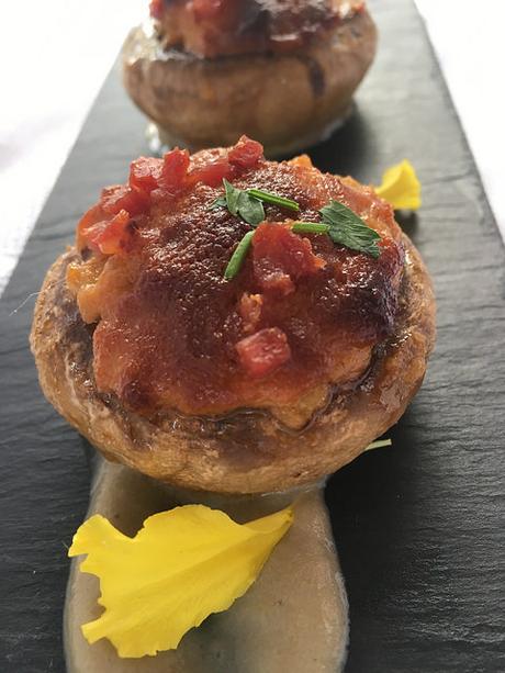 Champiñones rellenos de almogrote sobre salsa de berenjenas